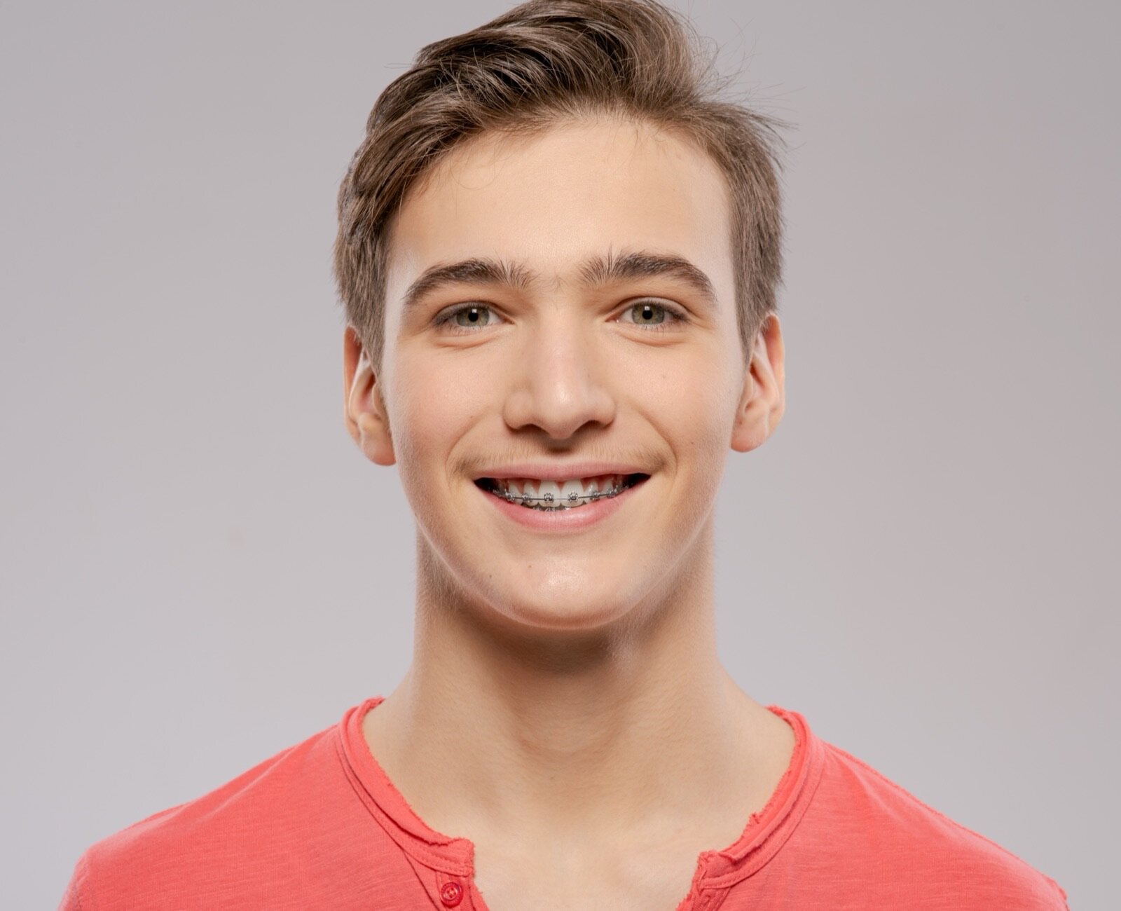 Smiling teenage patient wearing traditional metal braces