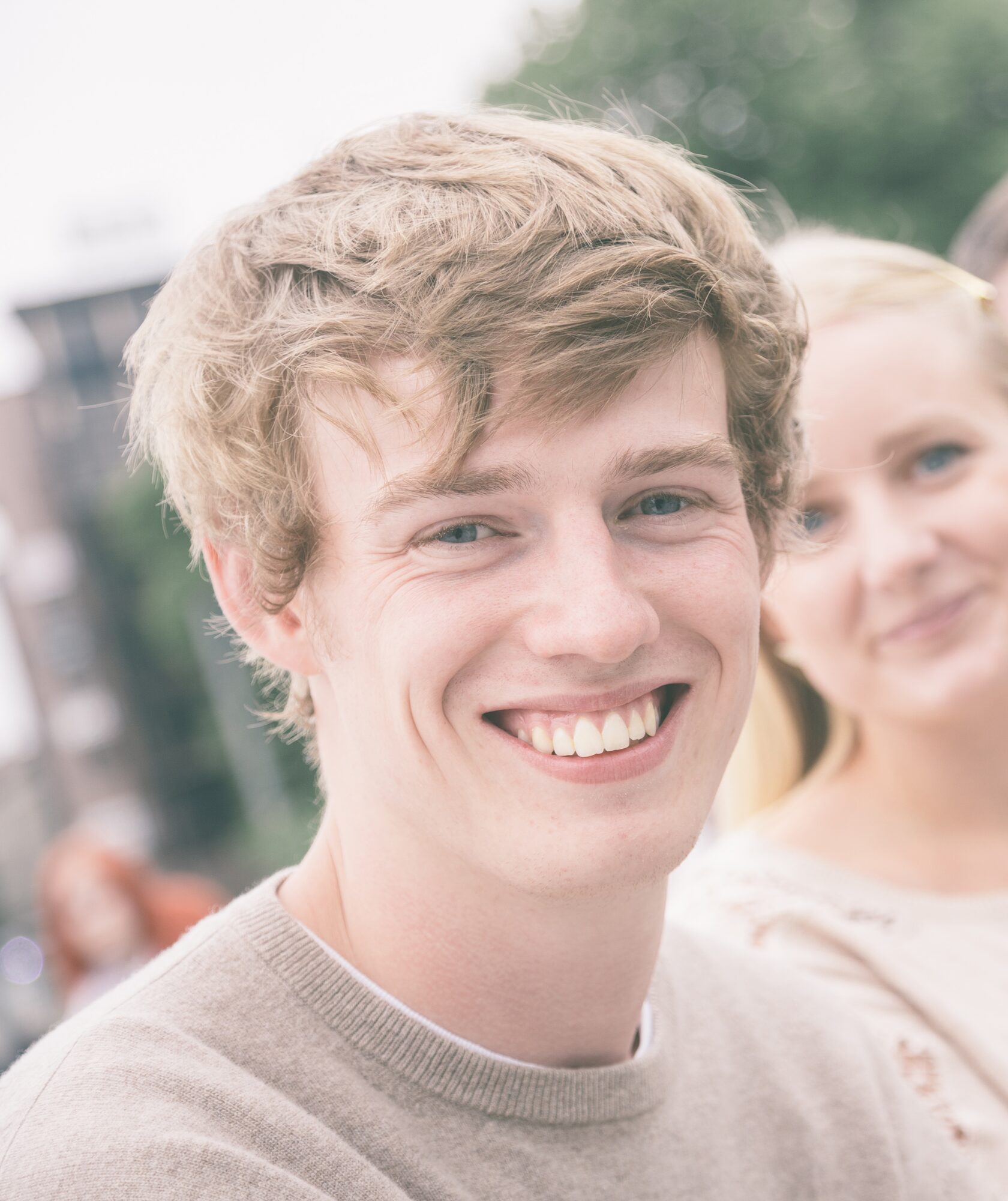 Smiling young man with friends outdoors - convenient orthodontic care for Hoboken residents