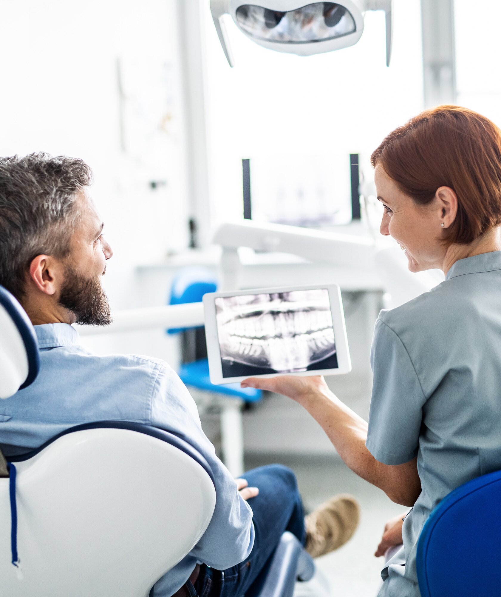 Orthodontic team member showing a patient a digital panoramic X-ray on a tablet